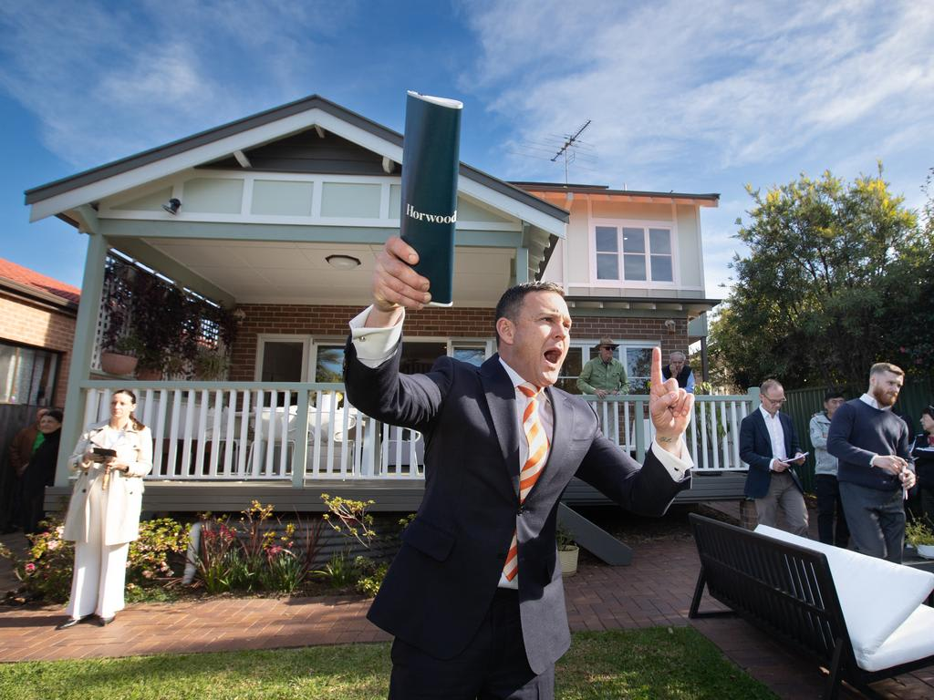 An auctioneer calling bids at a live on-site property auction